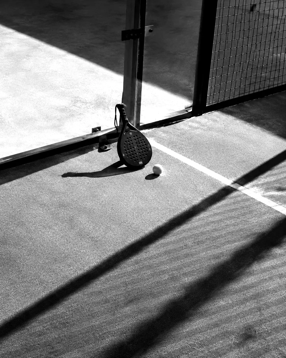 A padel racket and ball on a club court